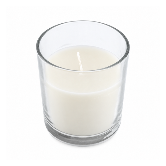 Una candelita de cera blanca en vaso transparente, sobre fondo blanco.