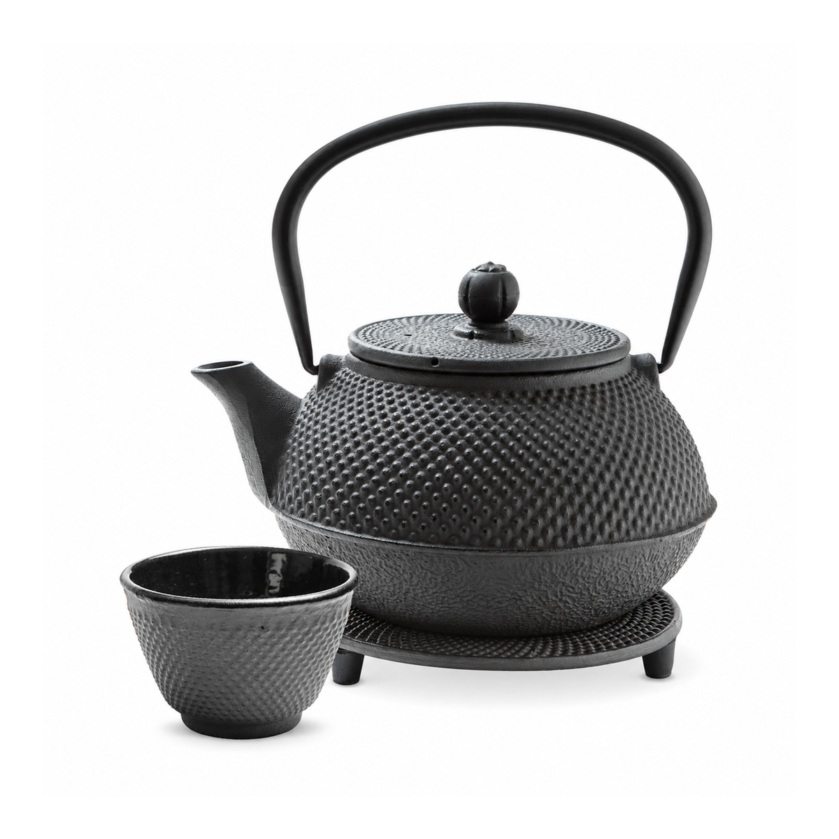 Tetera negra de hierro con una taza y base negra, sobre fondo blanco.