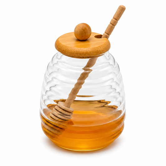 Dispensador de miel de vidrio acanalado con tapa de bambú y palito mielero.