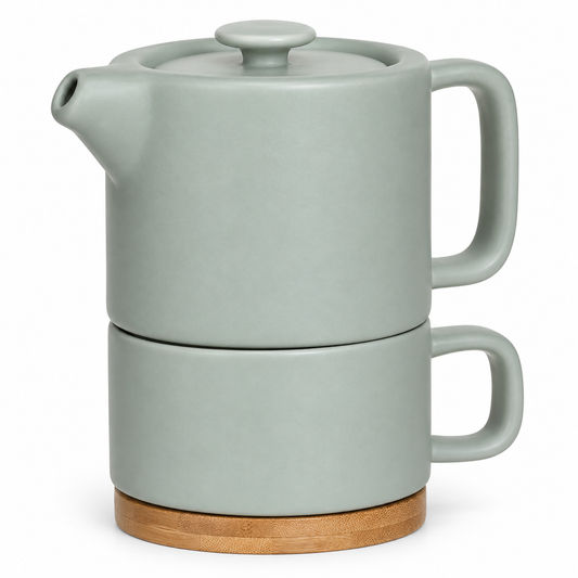 Tetera de loza color menta de 400 ml apilada sobre su taza con base de bambú.
